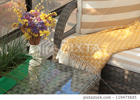 Wicker patio furniture and dry flowers on sunny autumn day in backyard. Garden furniture for relaxing. Wicker patio furniture and dry flowers on sunny autumn day in backyard. Garden furniture for relaxing. 119473685