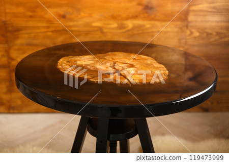 A stylish round table showcasing a stunning petrified wood top 119473999