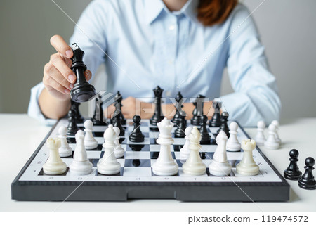 hand of businesswoman moving chess in competition shows leadership, followers and business success strategies 119474572