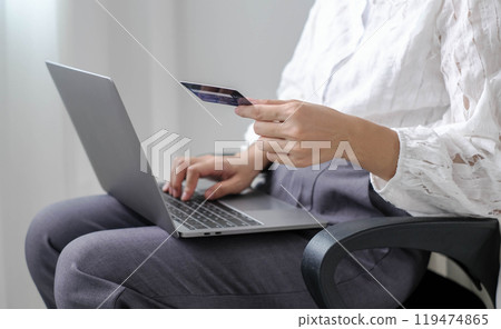 Asian woman shopping online using credit card and using laptop. Entering card number in laptop app to purchase and pay in online store Asian woman shopping online using credit card and using laptop. Entering card number in laptop app to purchase and pay in online store 119474865