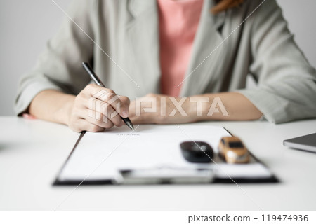Car dealer businesswoman signing car insurance document or lease paper. Car insurance, loans and Car rentals concept Car dealer businesswoman signing car insurance document or lease paper. Car insurance, loans and Car rentals concept 119474936