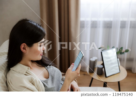 Young pregnant woman with baby belly using her mobile cell phone 119475140