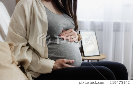 Pregnant woman or lady holding, touching her baby bump or belly with hands, arms Pregnant woman or lady holding, touching her baby bump or belly with hands, arms 119475142