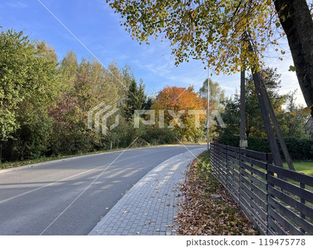 A two-lane road passing through a picturesque area. A sharp right turn on the road 119475778