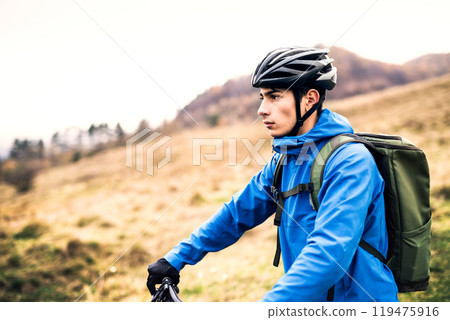 Active man on bike in the middle of beautiful nature, enjoying beautiful view. Concept of healthy lifestyle. Active man on bike in the middle of beautiful nature, enjoying beautiful view. Concept of healthy lifestyle. 119475916
