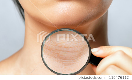A magnifying glass zooms in on the wrinkles on a woman in her 30s' neck. 119476112