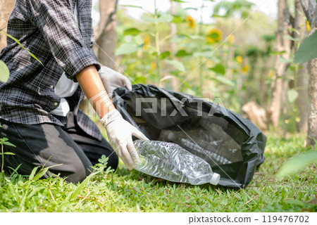 Hand pick up plastic bottles, put garbage in black garbage bags to clean up at parks, avoid pollution, be friendly to the environment and ecosystem Hand pick up plastic bottles, put garbage in black garbage bags to clean up at parks, avoid pollution, be friendly to the environment and ecosystem 119476702