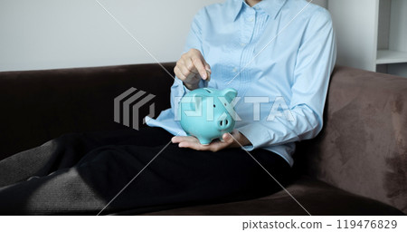 A young woman teaches how to put coins in a piggy bank start a growing business for success and save for retirement concept A young woman teaches how to put coins in a piggy bank start a growing business for success and save for retirement concept 119476829