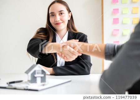 Businesswoman and brokers real estate agents shake hands after completing negotiations to buy house insurance and sign contracts. Home insurance concept 119477039