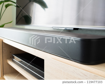A soundbar in front of a large TV A soundbar in front of a large TV 119477103