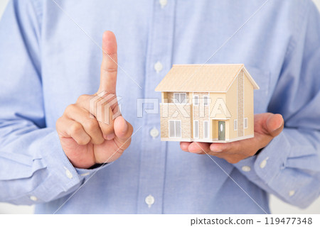 一名中年男子的手拿著房屋模型並舉起食指 119477348