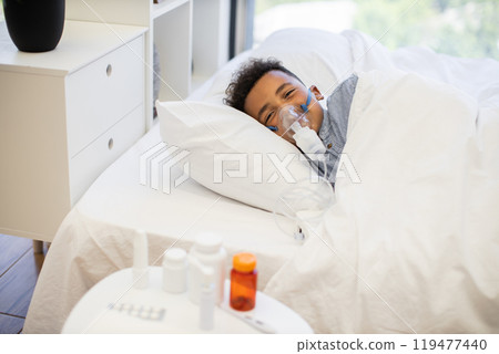 Young boy using nebulizer for respiratory treatment at home 119477440