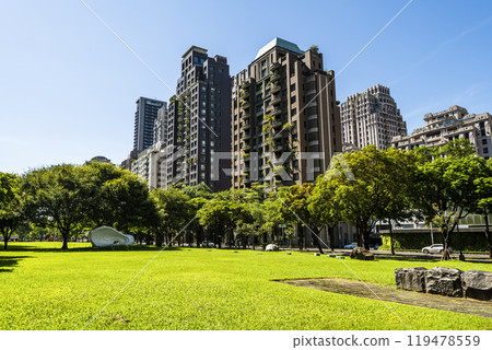 Low-angle view of green park space and modern buildings on both sides in downtown Taichung, Taiwan, It is near the National Taichung Theater. 119478559