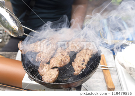 一個男人在戶外烤牛肉和牛肉 119479856