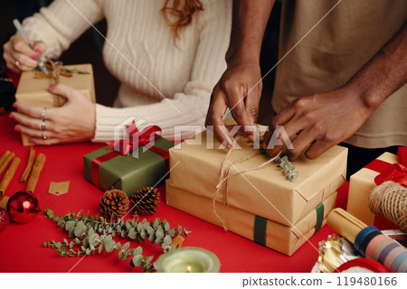 Wrapping Holiday Gifts with Pinecones and Ribbons 119480166