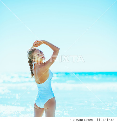 Happy young woman standing in sea 119481238