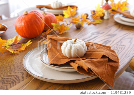 Autumn, fall, Halloween or Thanksgiving day table setting. Plates with yellow leaves and pumpkins Autumn, fall, Halloween or Thanksgiving day table setting. Plates with yellow leaves and pumpkins 119481289