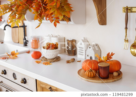 Autumn kitchen decor, pumpkins and colorful leaves in cozy home setting for fall holidays 119481299