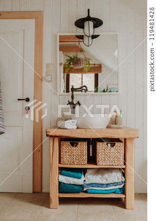 Modern attic bathroom with a wooden sink table. 119481428