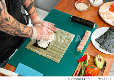 Preparing sushi rolls with fresh ingredients at a culinary studio 119481507