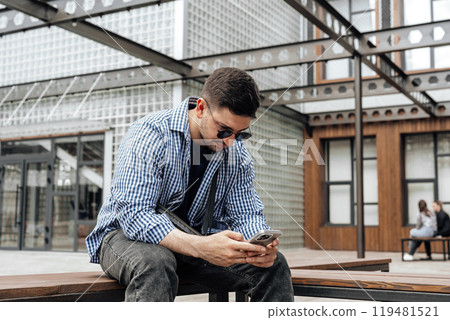 Young man sitting on a bench in a park 119481521