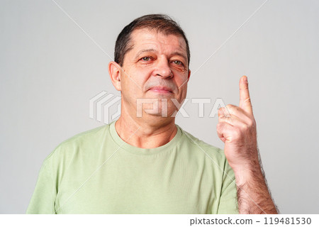 A man in a light green shirt raises his finger, signifying an important message A man in a light green shirt raises his finger, signifying an important message 119481530