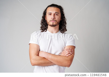 A young man stands thoughtfully against a plain background, expressing contemplation A young man stands thoughtfully against a plain background, expressing contemplation 119481548