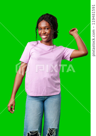 Joyful woman celebrating success with clenched fists against a bright green background Joyful woman celebrating success with clenched fists against a bright green background 119481591