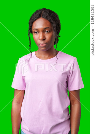 Young woman with an expression of contemplation poses against a bright green background Young woman with an expression of contemplation poses against a bright green background 119481592