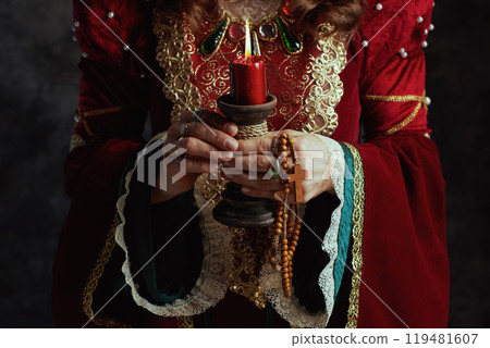 Closeup on medieval queen in red dress with candle Closeup on medieval queen in red dress with candle 119481607