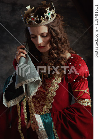 sad medieval queen in red dress with handkerchief crying 119481611