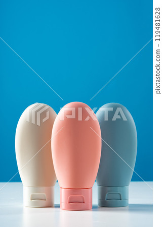 Variety of travel-sized containers displayed against a bright blue background 119481628