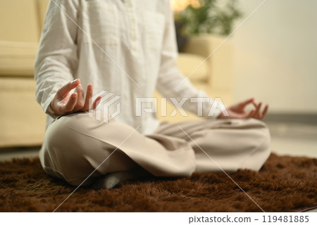 Serene young woman meditating at home. Yoga and healthy lifestyle concept 119481885