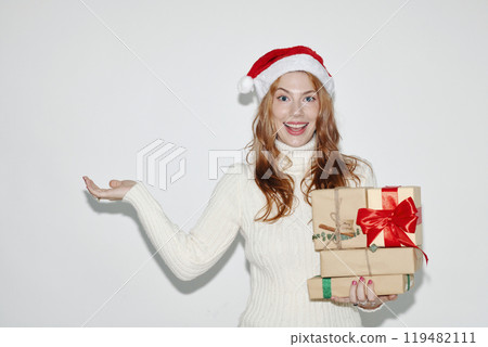 Smiling Woman Wearing Santa Hat Holding Gift Boxes 119482111