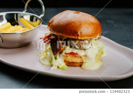 Juicy gourmet burger with melted cheese, bacon, and fries.Perfect for a delicious treat Juicy gourmet burger with melted cheese, bacon, and fries.Perfect for a delicious treat 119482323