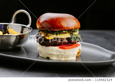 Gourmet burger with grilled pineapple, herb topping, and fries, perfect for exotic meal experience 119482324
