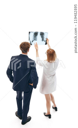 Female doctor, healthcare professional and businessman analyzing X-ray results. Professional consultation in medicine. Female doctor, healthcare professional and businessman analyzing X-ray results. Professional consultation in medicine. 119482895