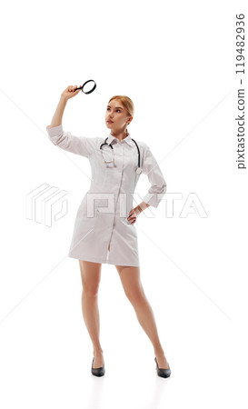 Female doctor in white gown standing with magnifying glass, isolated on white background Female doctor in white gown standing with magnifying glass, isolated on white background 119482936