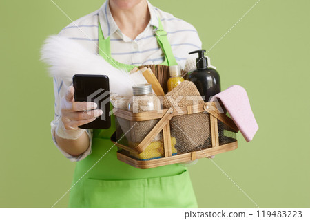 Modern female in green apron and rubber gloves on green 119483223