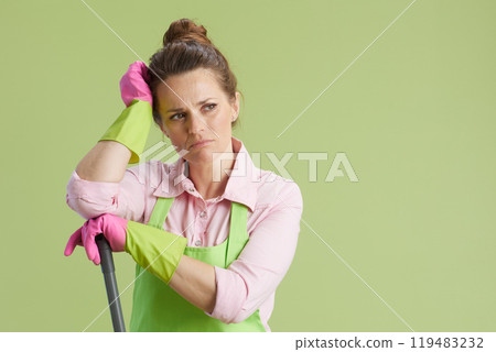 confused housewife in green apron and rubber gloves on green 119483232