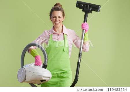 smiling 40 years old woman vacuum cleaner against green smiling 40 years old woman vacuum cleaner against green 119483234