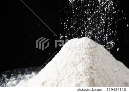 Coconut flour spilling on pile, natural coconut flour texture on black background. 119484118