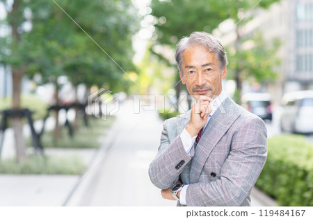 Senior businessman with arms folded in an office district 119484167