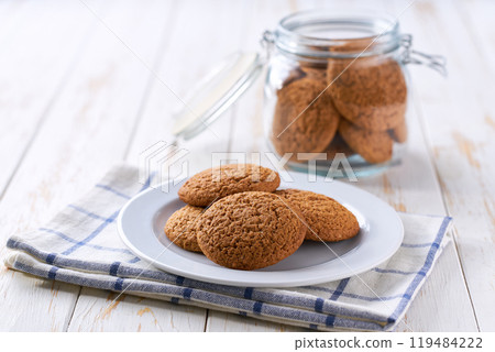 oatmeal cookies in glass jar and on white table, selective focus. 119484222