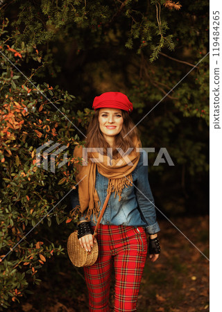happy modern 40 years old woman in jeans shirt and red hat 119484265