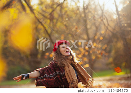 smiling elegant woman in red hat with scarf rejoicing 119484270