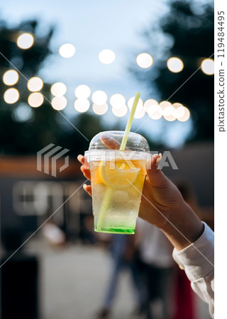 Refreshing lemonades in vibrant colors, raised in a cheerful toast against glowing bokeh background Refreshing lemonades in vibrant colors, raised in a cheerful toast against glowing bokeh background 119484495