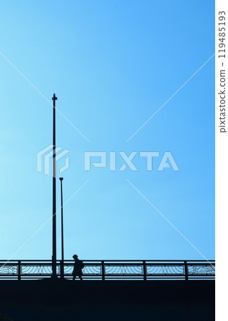 People crossing an overpass under a blue sky People crossing an overpass under a blue sky 119485193