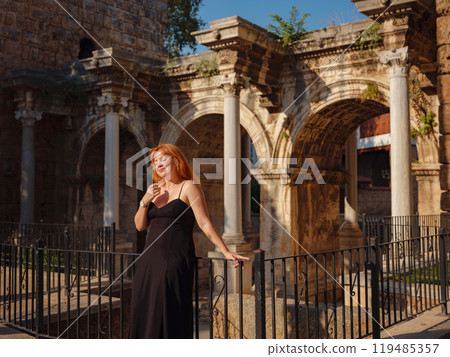 Young woman in elegant black dress walking in cozy old town Keleci, Antalya, Turkey during summer day. female traveler discover interesting places and popular attractions Young woman in elegant black dress walking in cozy old town Keleci, Antalya, Turkey during summer day. female traveler discover interesting places and popular attractions 119485357