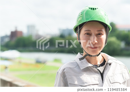 A woman in work clothes and a helmet conducting a river survey A woman in work clothes and a helmet conducting a river survey 119485384